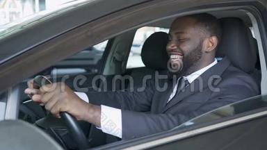 美国黑人男子坐在昂贵的汽车上满意而微笑，<strong>试驾</strong>